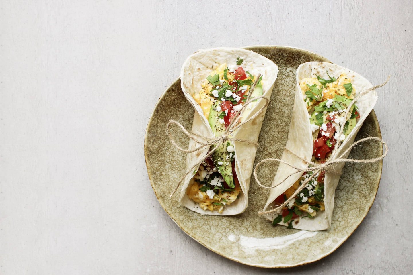 Breakfast Tacos mit Kräutern Rustikana auf einem beigen Teller mit einem Faden zusammengebunden