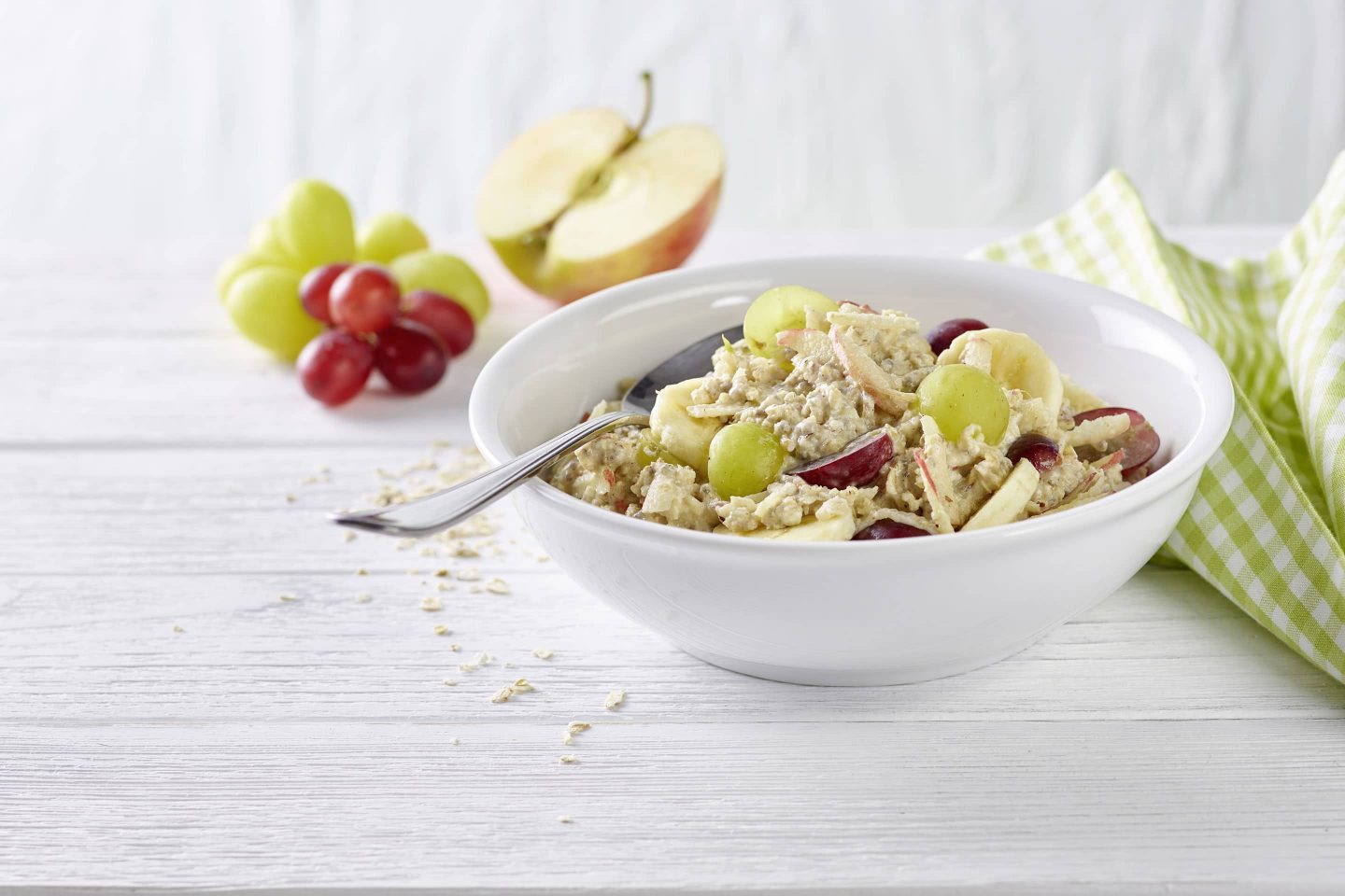 Powermuesli mit Kokosflocken, frischen Trauben und Zimt in einer weißen Schüssel