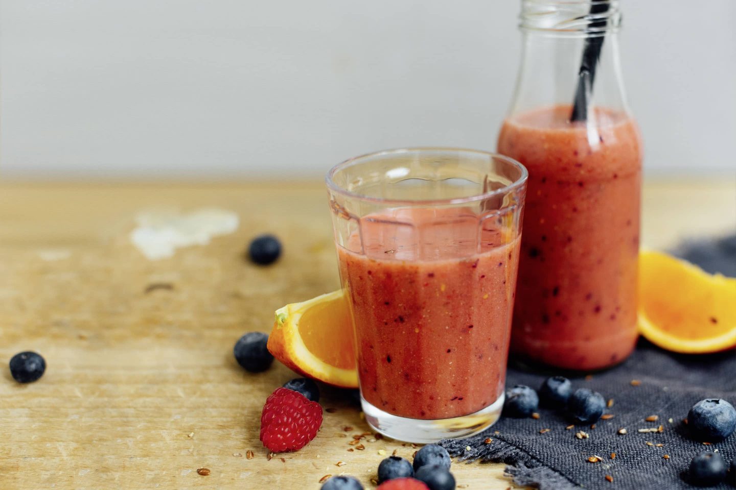 Red Power-Smoothie mit Cayennepfeffer in einem Glas und einer Flasche mit Strohhalm