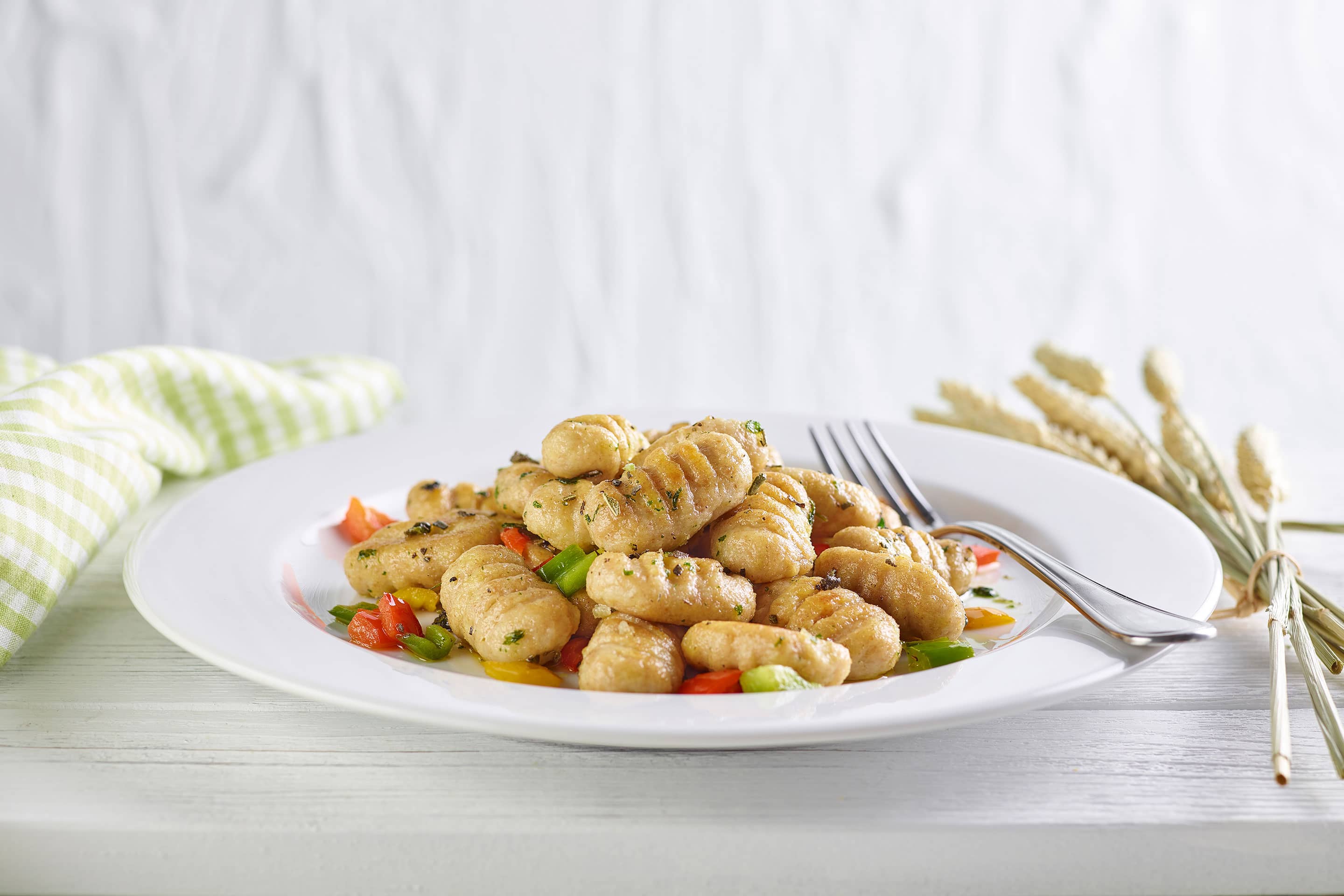 Vollkorn Gnocchi mit frischem Salbei und Paprika auf einem weißen Teller