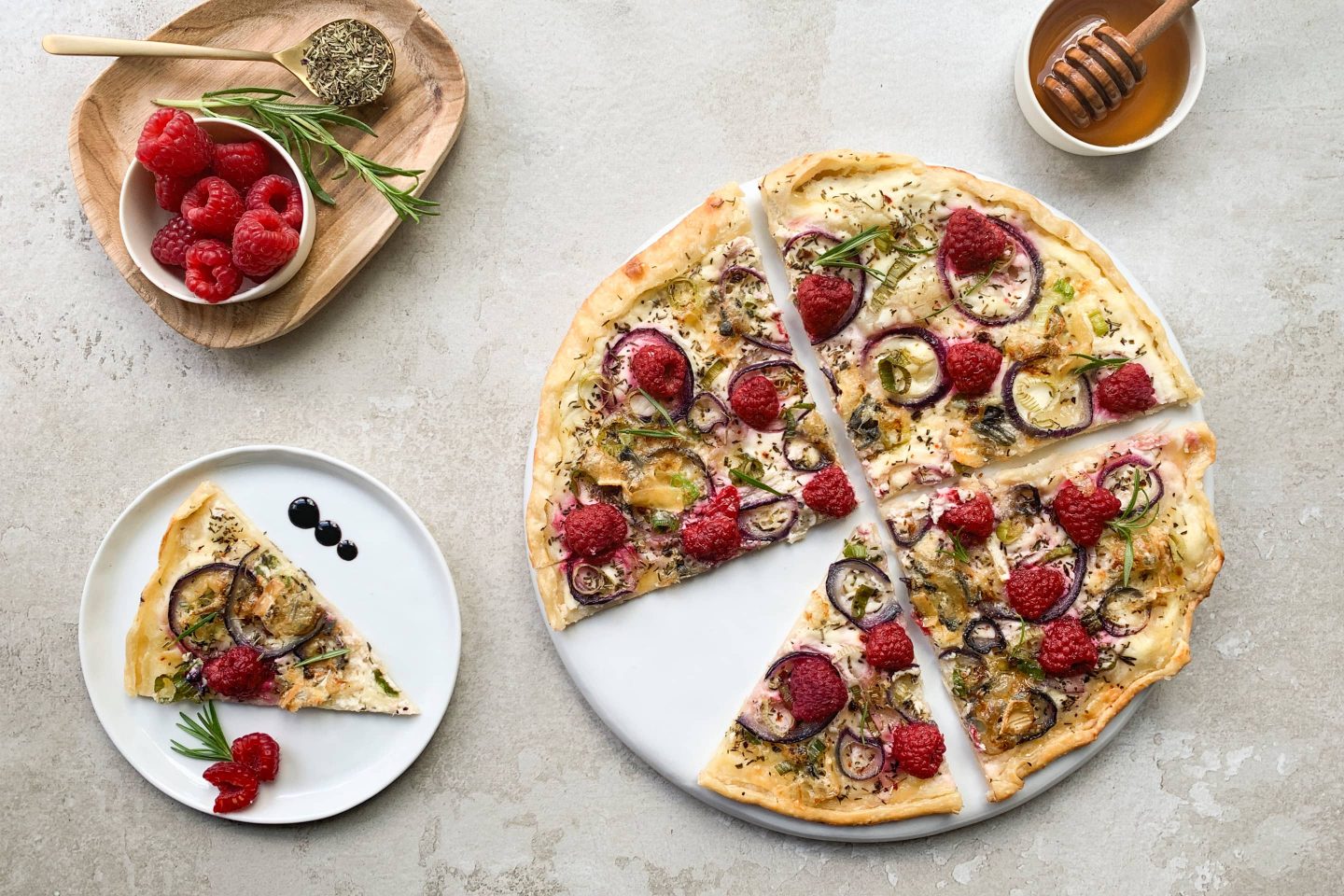 Flammkuchen mit Blauschimmelkäse, roter Zwiebel, Himbeeren und Kräuter Rustikana