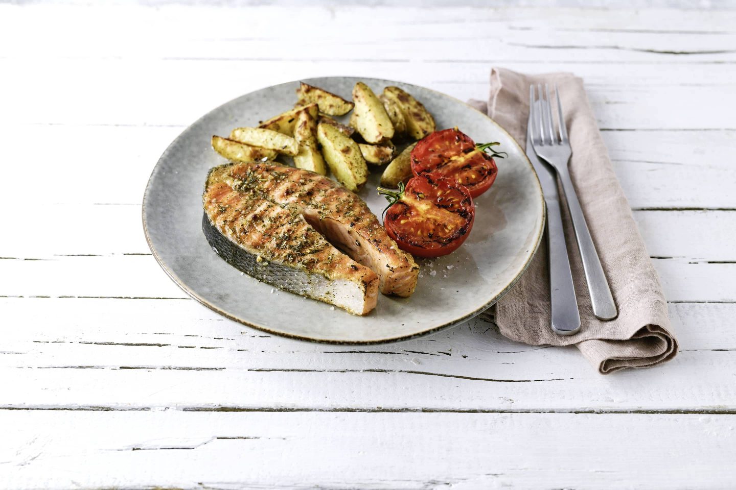 Lachssteak mit Grill-Fisch, Grilltomaten und Kartoffewedges