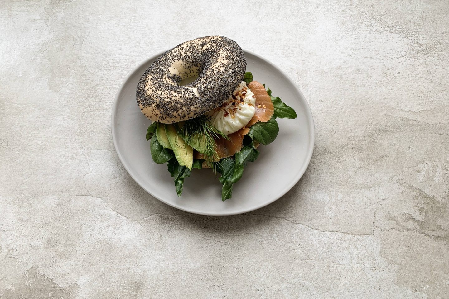 Bagel mit Lachs, Avocado, pochiertem Ei gefült