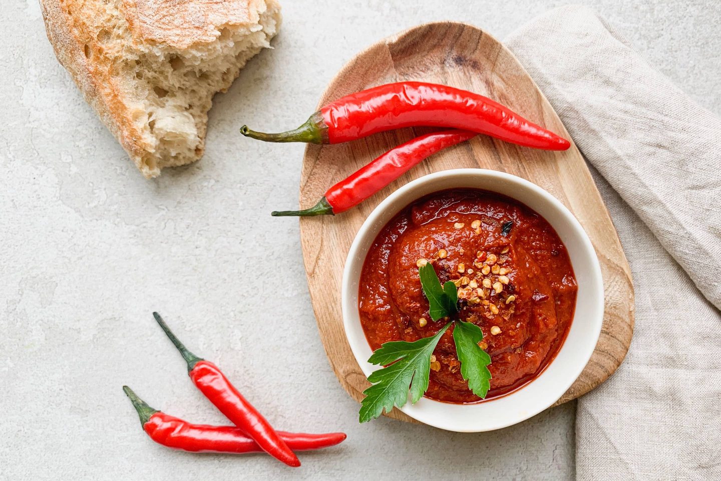 Chili-Amazonas-Dip in einer kleinen weißen Schale mit frischen Chilischoten und etwas Brot angerichtet