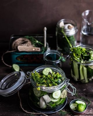 Gurkenscheiben mit Senfblüten und Körnern in Einmachglas
