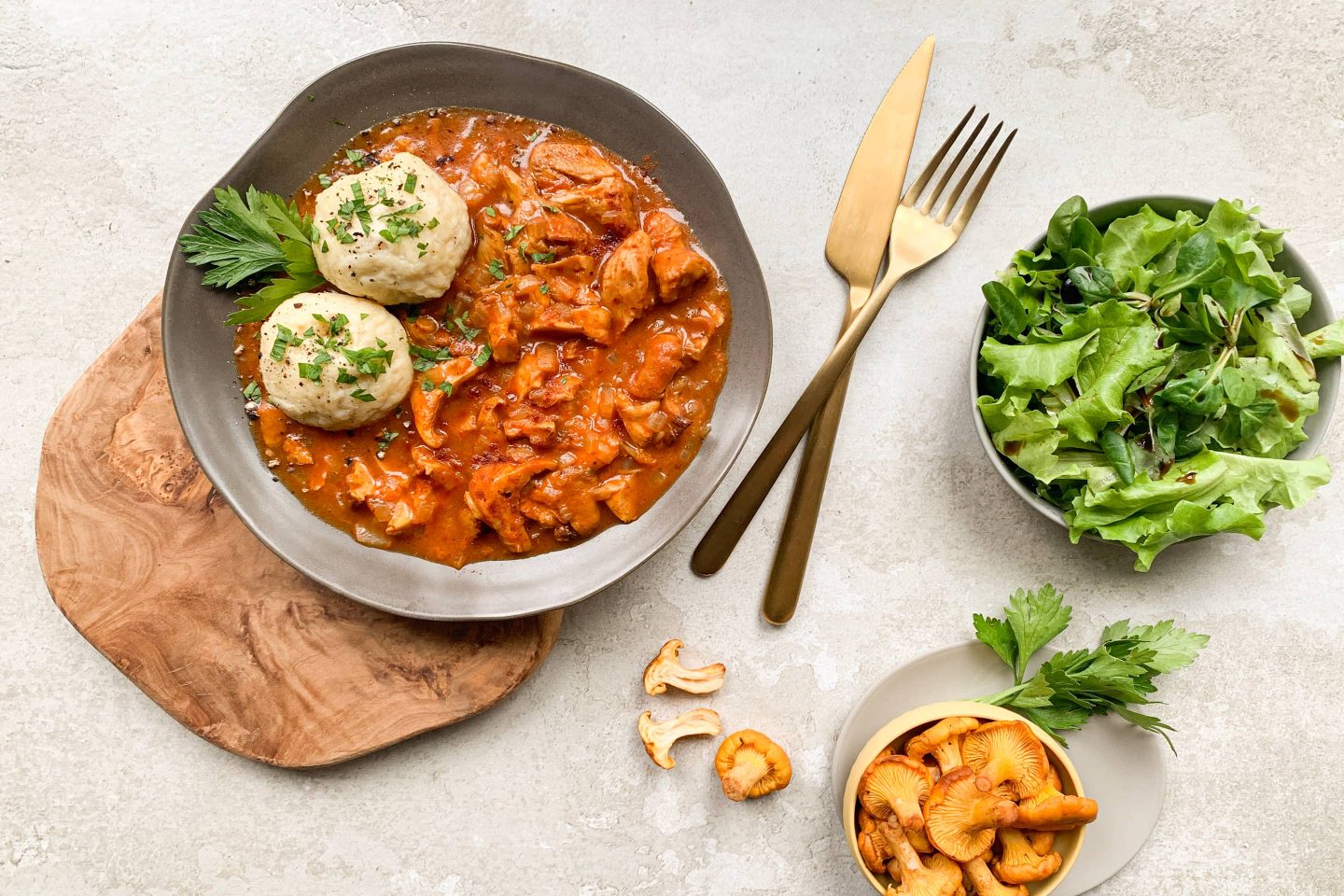 Ricotta-Knödel und Eierschwammerl-Gulasch mit frischem Salat angerichtet