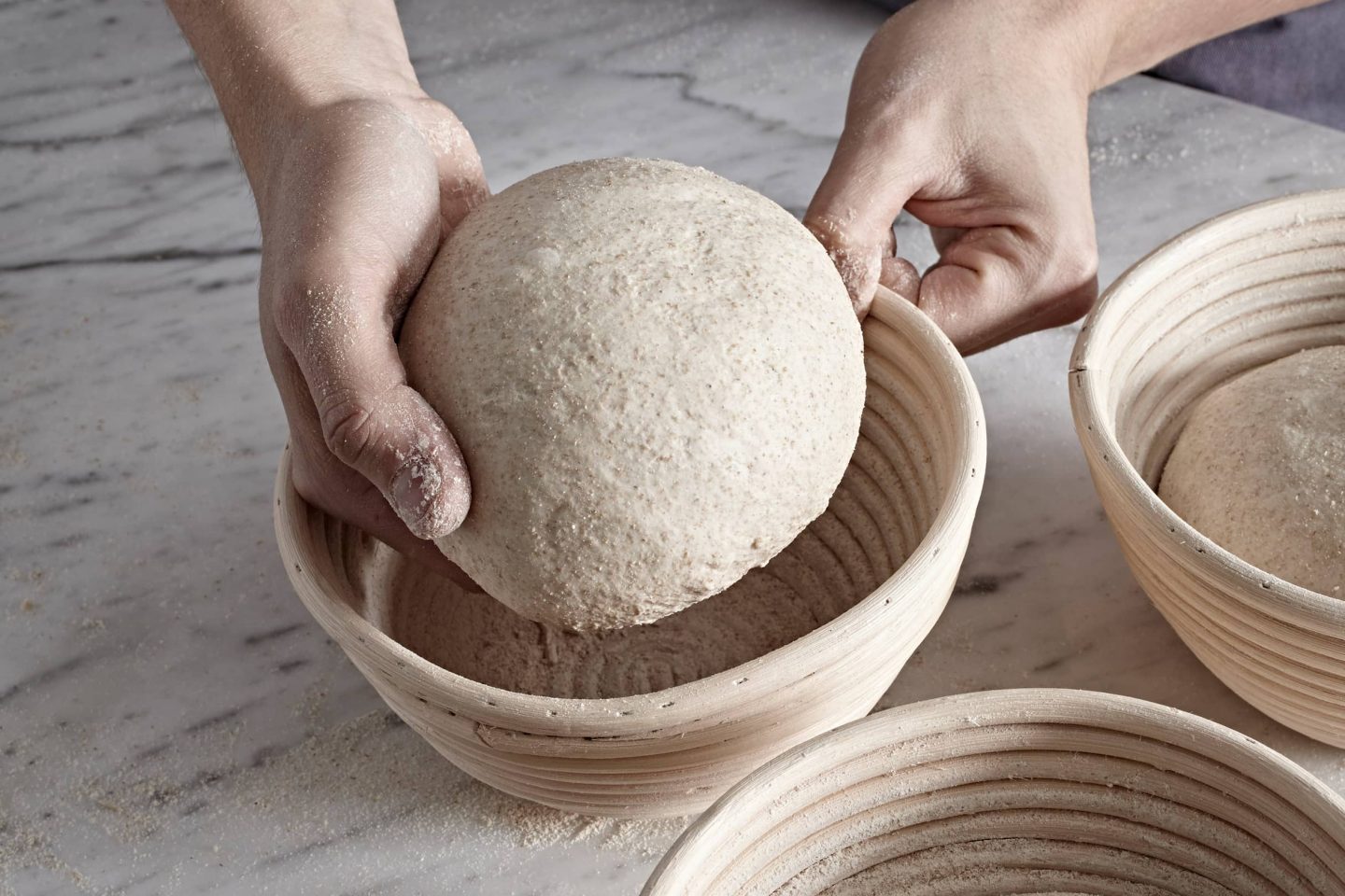Die per Hand geformten Sauerteiglaibe werden in Backformen gelegt