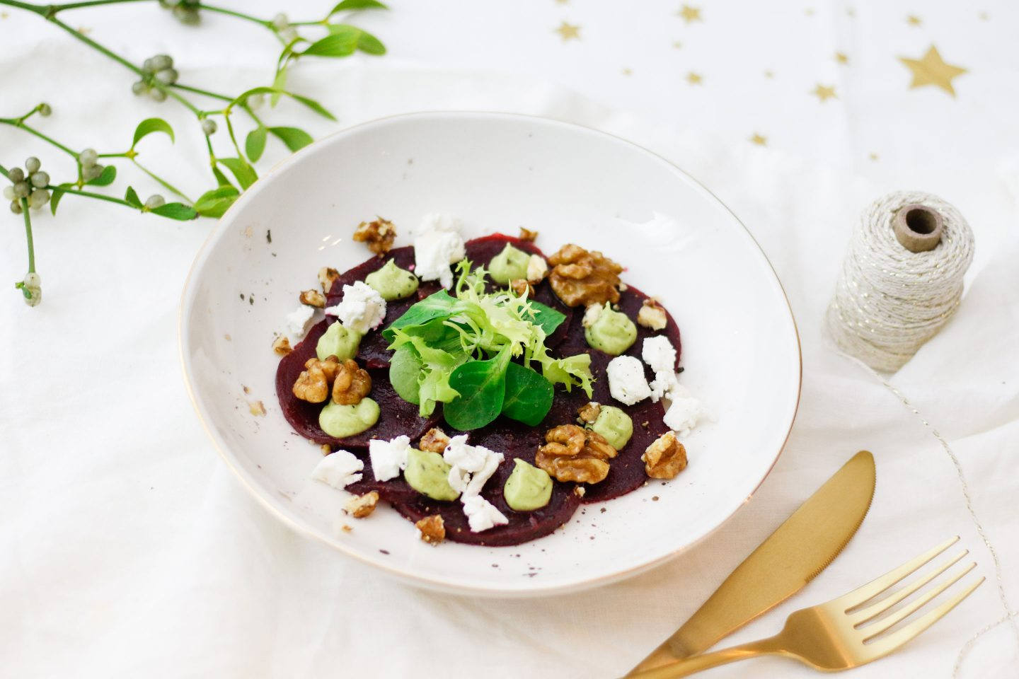Ein Carpaccio aus Roten Rüben mit frischem Ziegenkäse auf einem tiefen Teller angerichtet