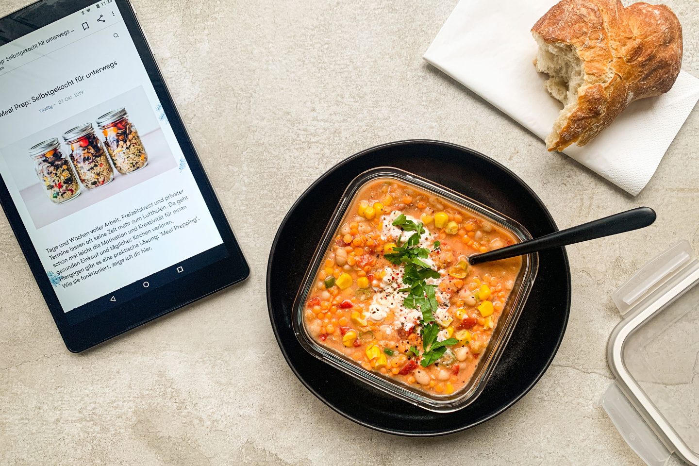 Feuriges Rote Linsen Chili mit Mais, weißen Bohnen und Sauerrahm in einer Mealprep-Form für unterwegs zubereitet