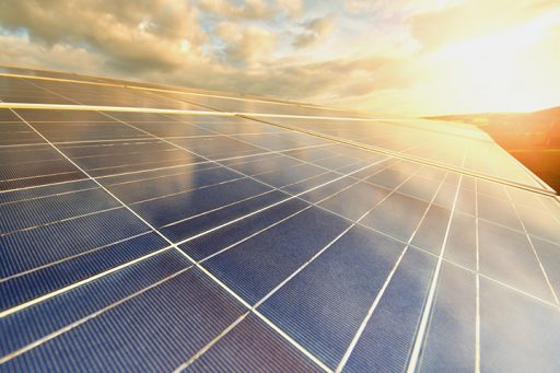 Photovoltaikanlage vor einem sonnig-wolkigen Himmel