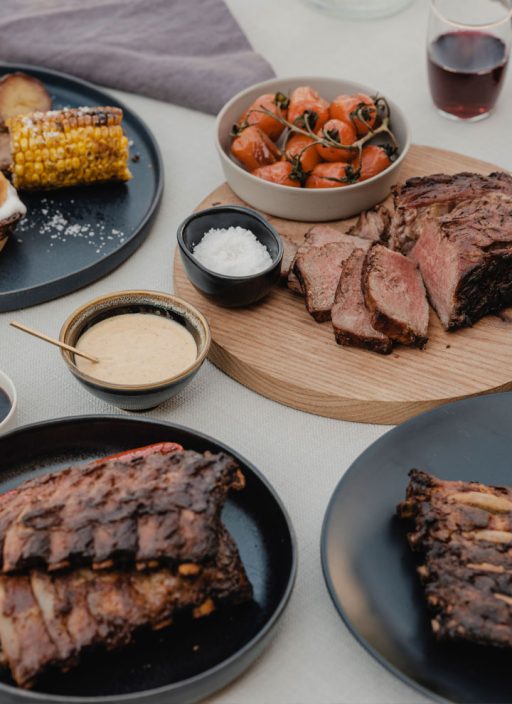 Ein gedeckter Tisch mit gegrilltem Fleisch und Saucen