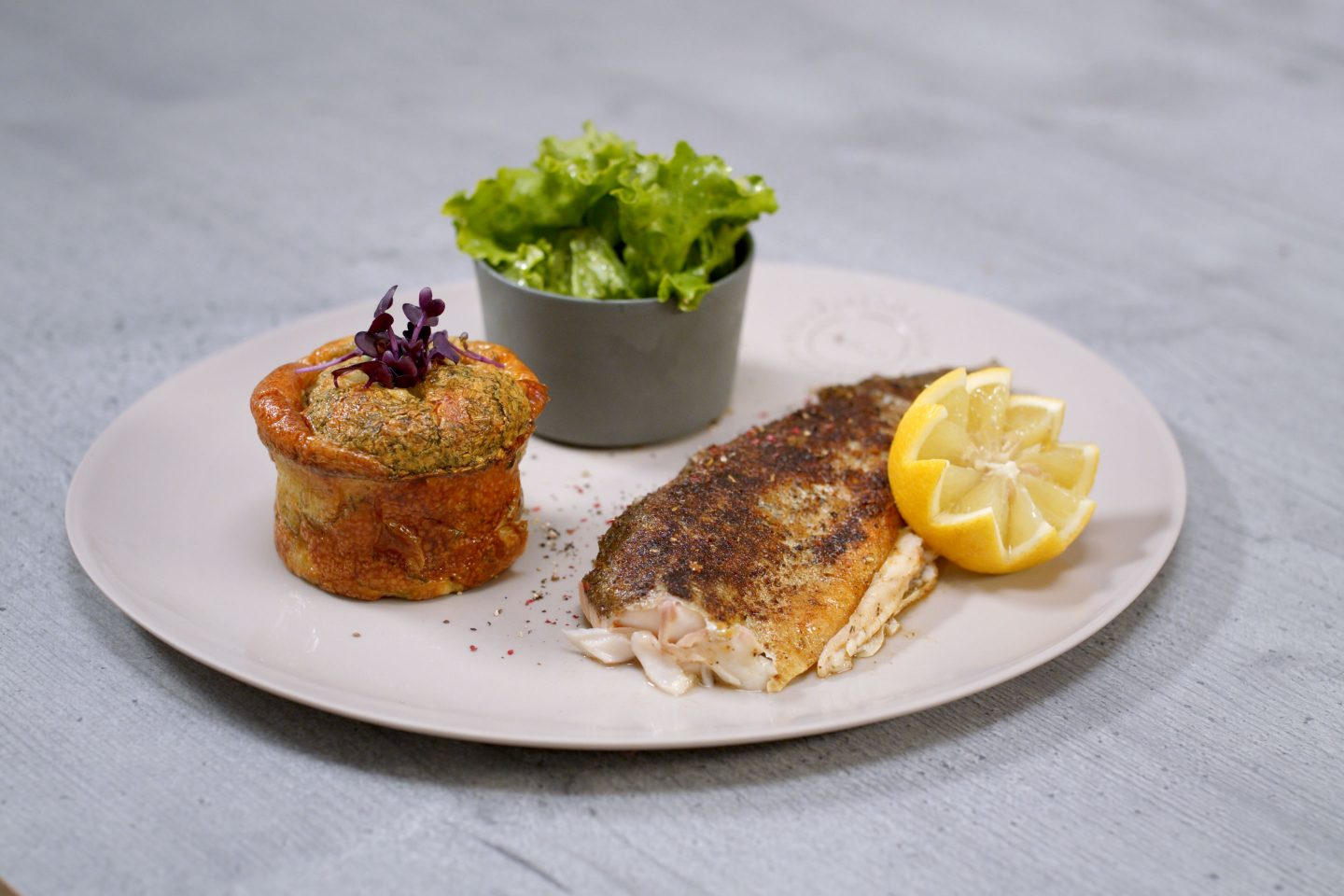 Forelle mit Kartoffelkuchen und frischem, grünen Salat in einem Schälchen