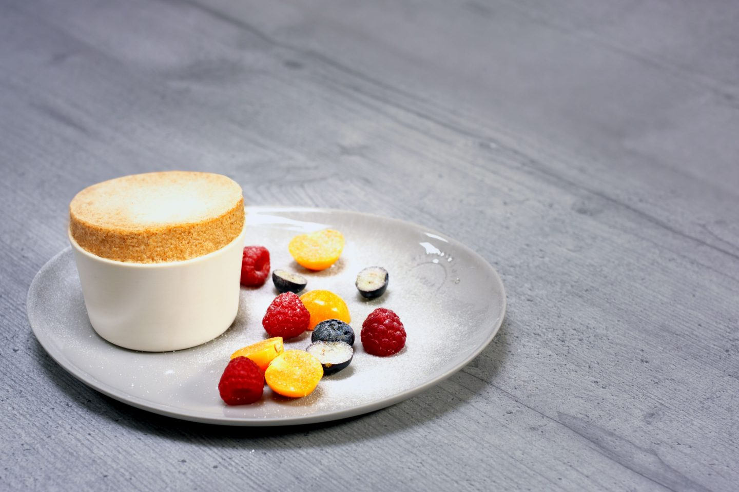 weiße Schookolade-Lebkuchen Souffle mit Staubzucker gezuckert und frischen Beeren und Physalis garniert