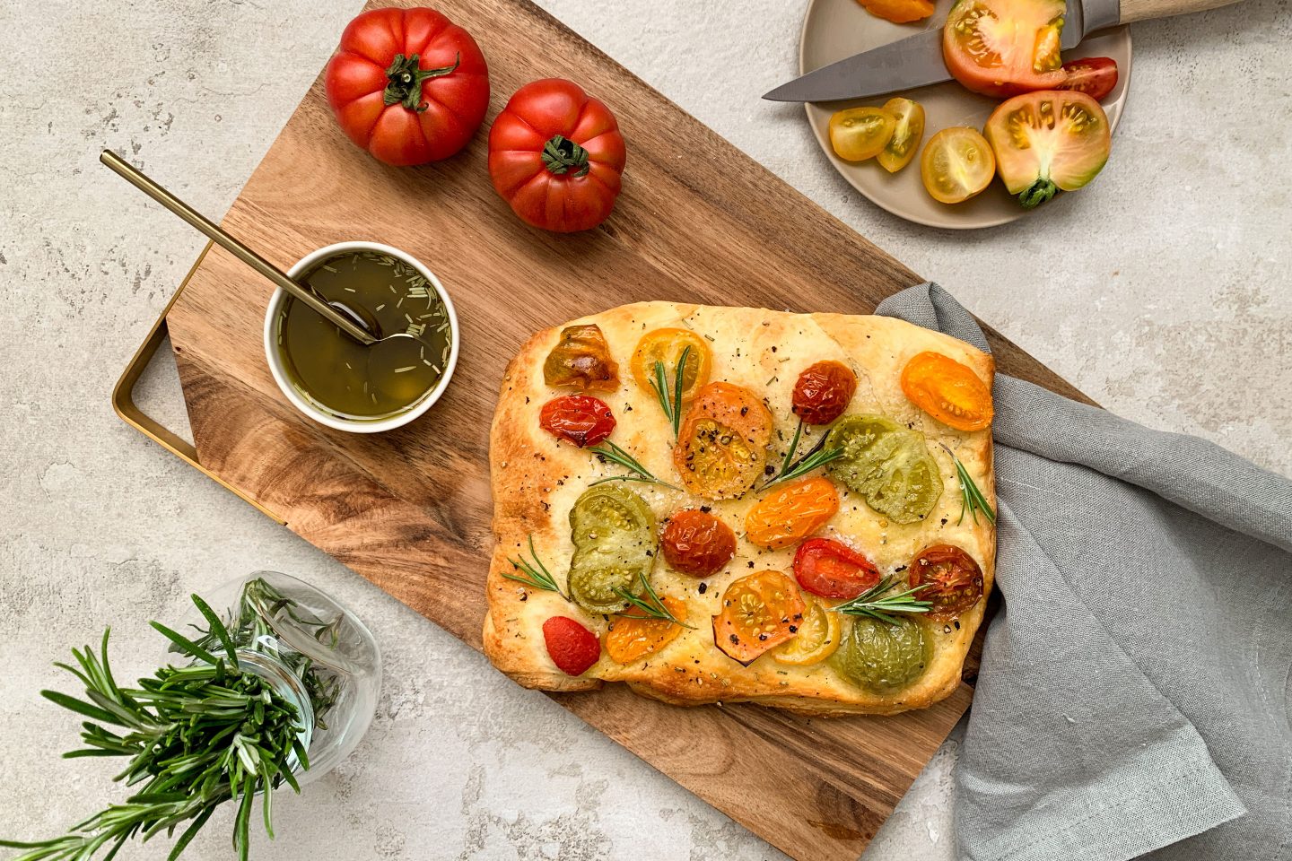 mit Tomaten belegte, rechteckige Focaccia auf einem Holzbrett