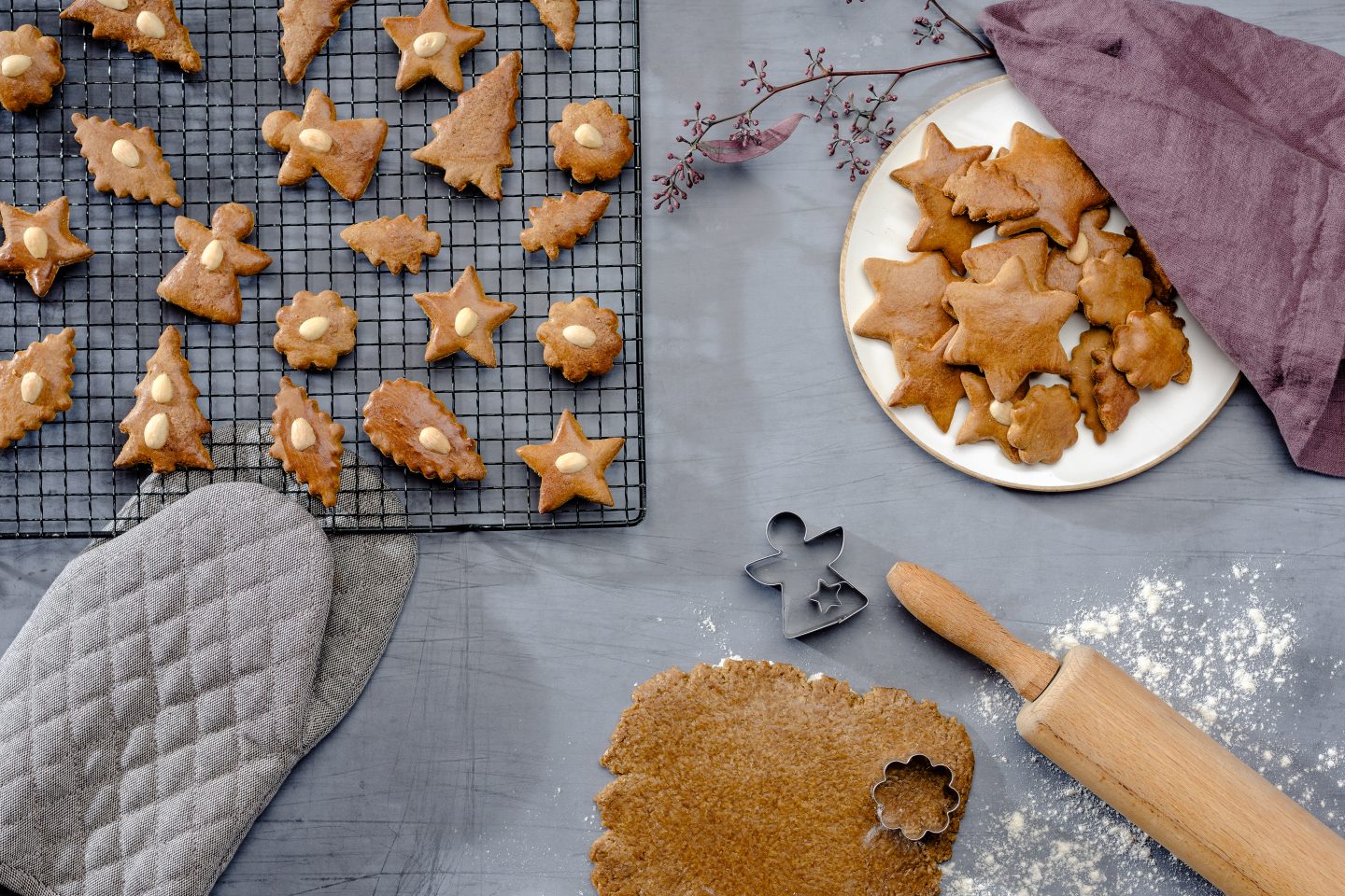 Honiglebkuchen werden gerade aus Teig ausgestochen und liegen zum Abkühlen auf einem schwarzen Kuchengitter