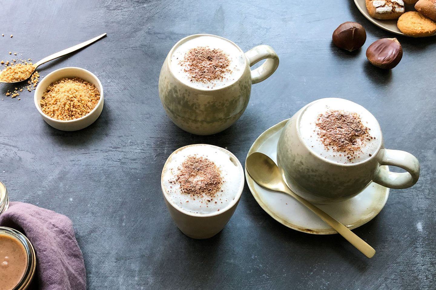 Maroni Spice Latte in 2 bauchigen Tassen mit Salted Caramel Kaffeegewürz getoppt auf dunklem Untergrund