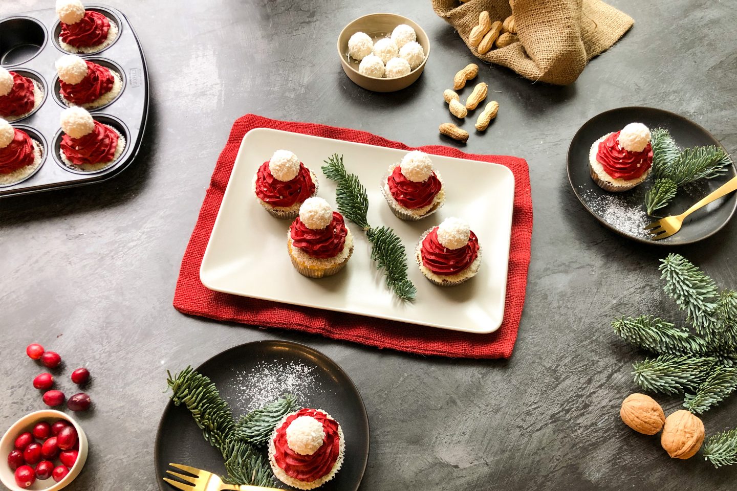 Nikolaus Cupcakes mir roter Creme-Haube auf einem eckigen Teller, mit Tannenzweigen dekoriert