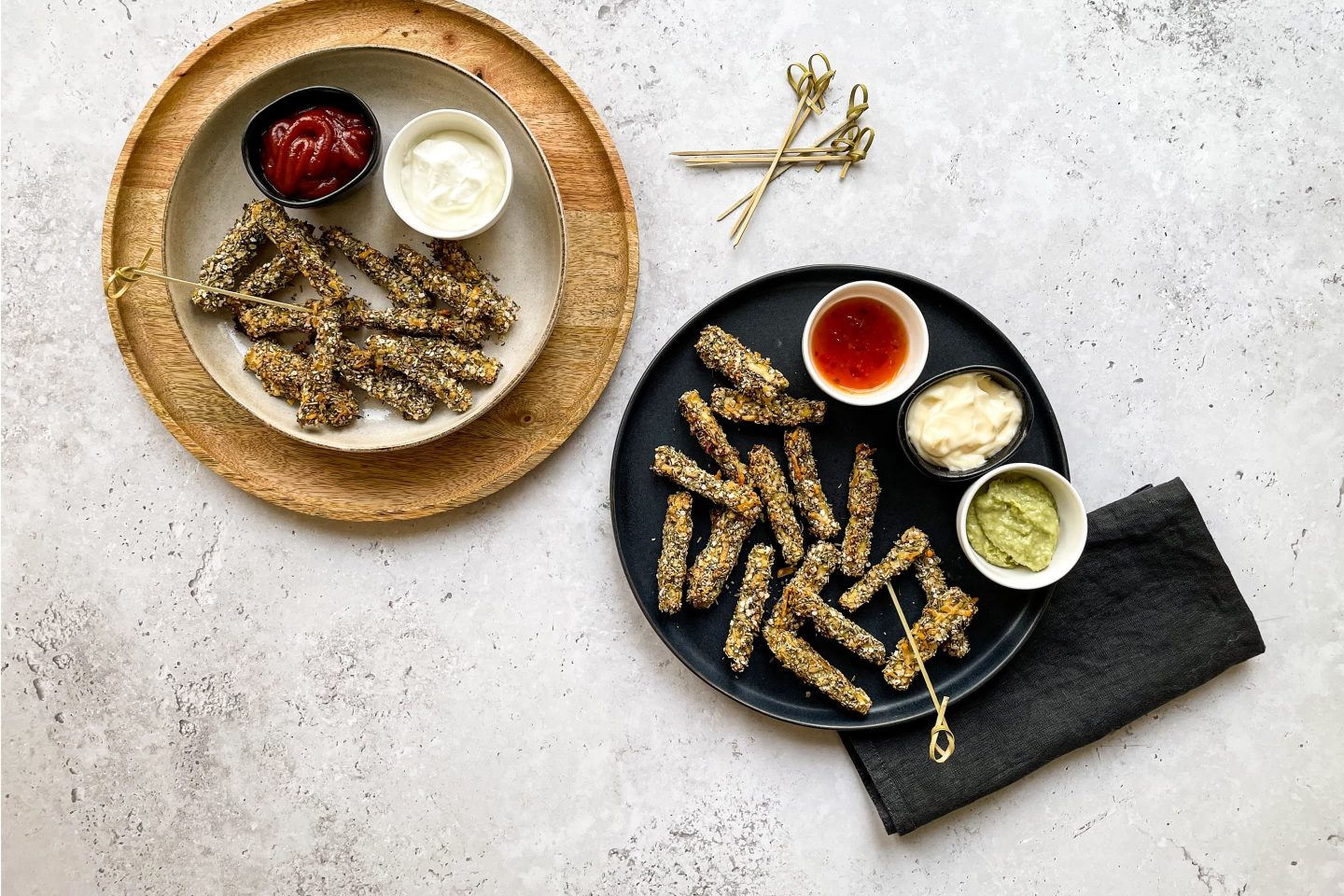 Ein Tisch mit zwei Portionen Quinoa-Tofu-Sticks und dazu mehrere Dips.