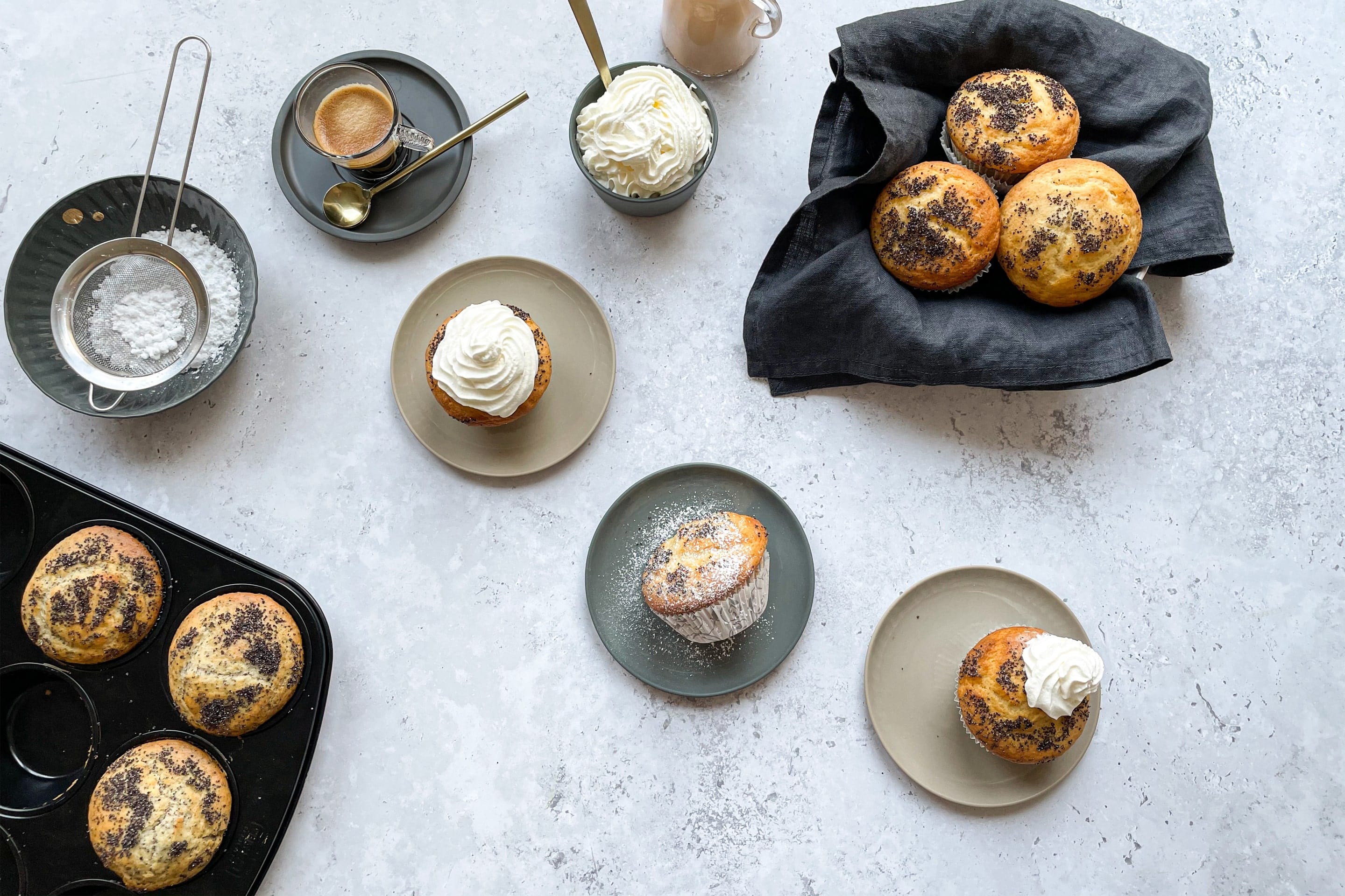 Eierlikör-Muffins frisch aus dem Ofen mit Schlagobers, Kaffee und Staubzucker.
