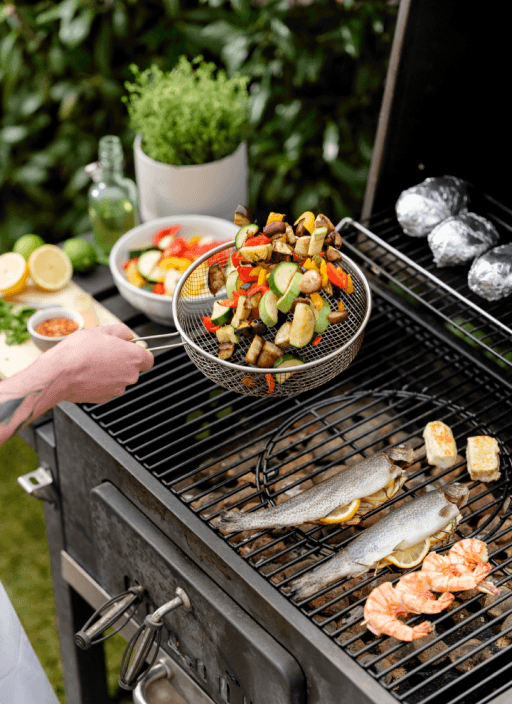 Grillgemüse, Fisch, Grillkäse und Kartoffeln auf einem Grill