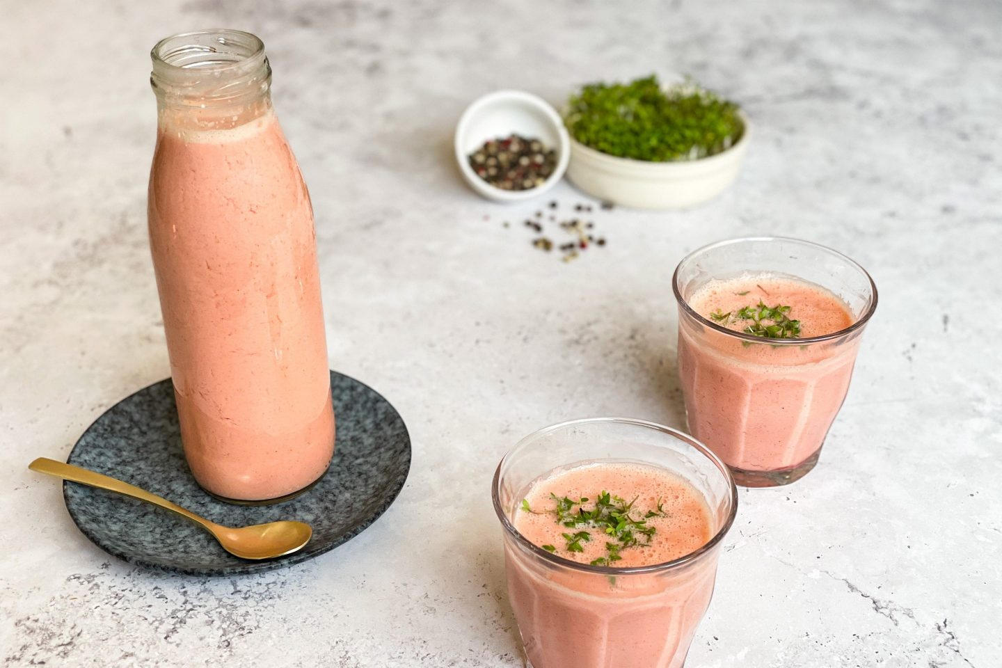 Zwei Gläser frischer cremiger Radieschen-Smoothie mit Kresse garniert.