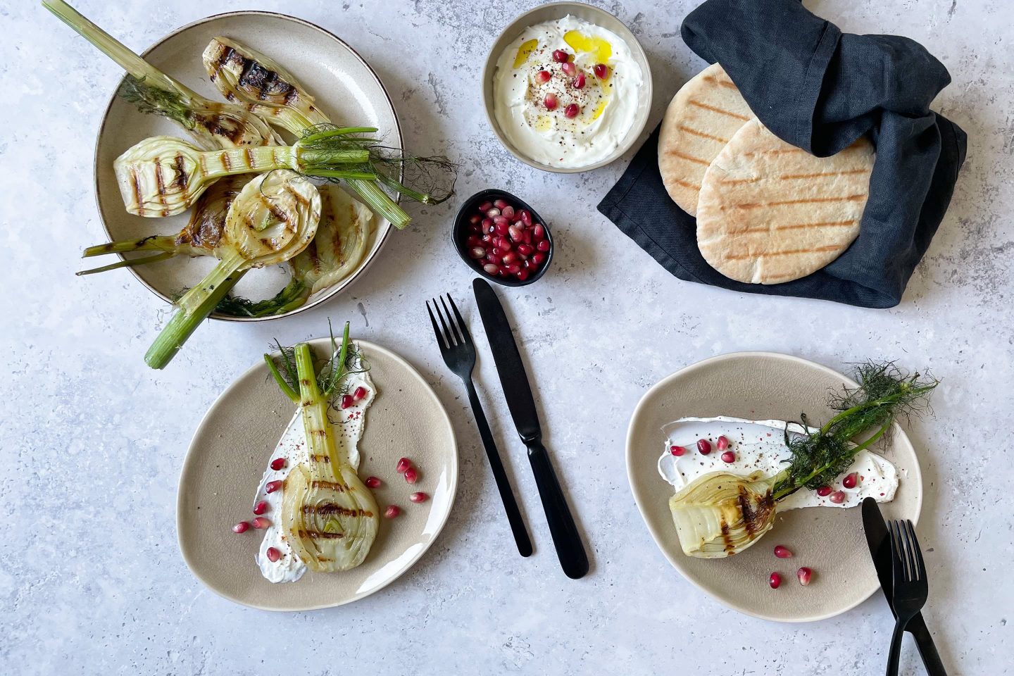 Fenchelknollen vom Grill auf Zitronen-Labneh mit Granatapfelkernen und Pita.