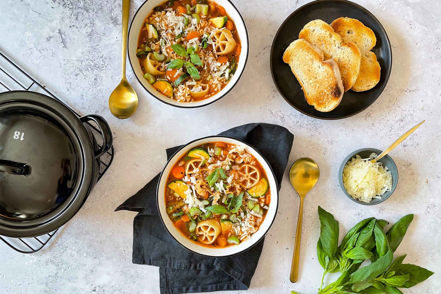 Zwei Schüsseln Minestrone mit frisch getoastetem Weißbrot und Parmesan.