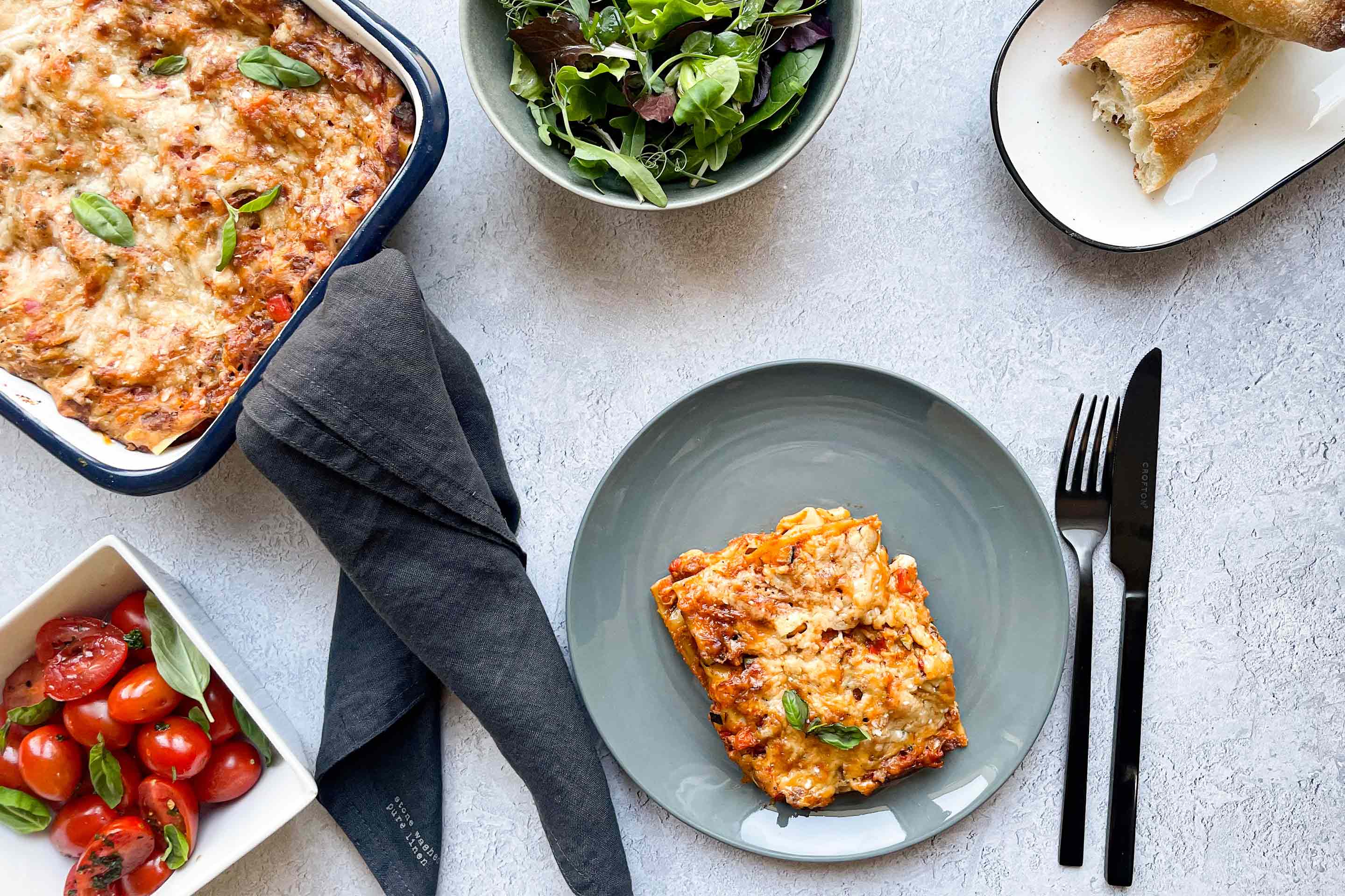 Vegane Lasagne mit Blattsalat und frischem Baguette.