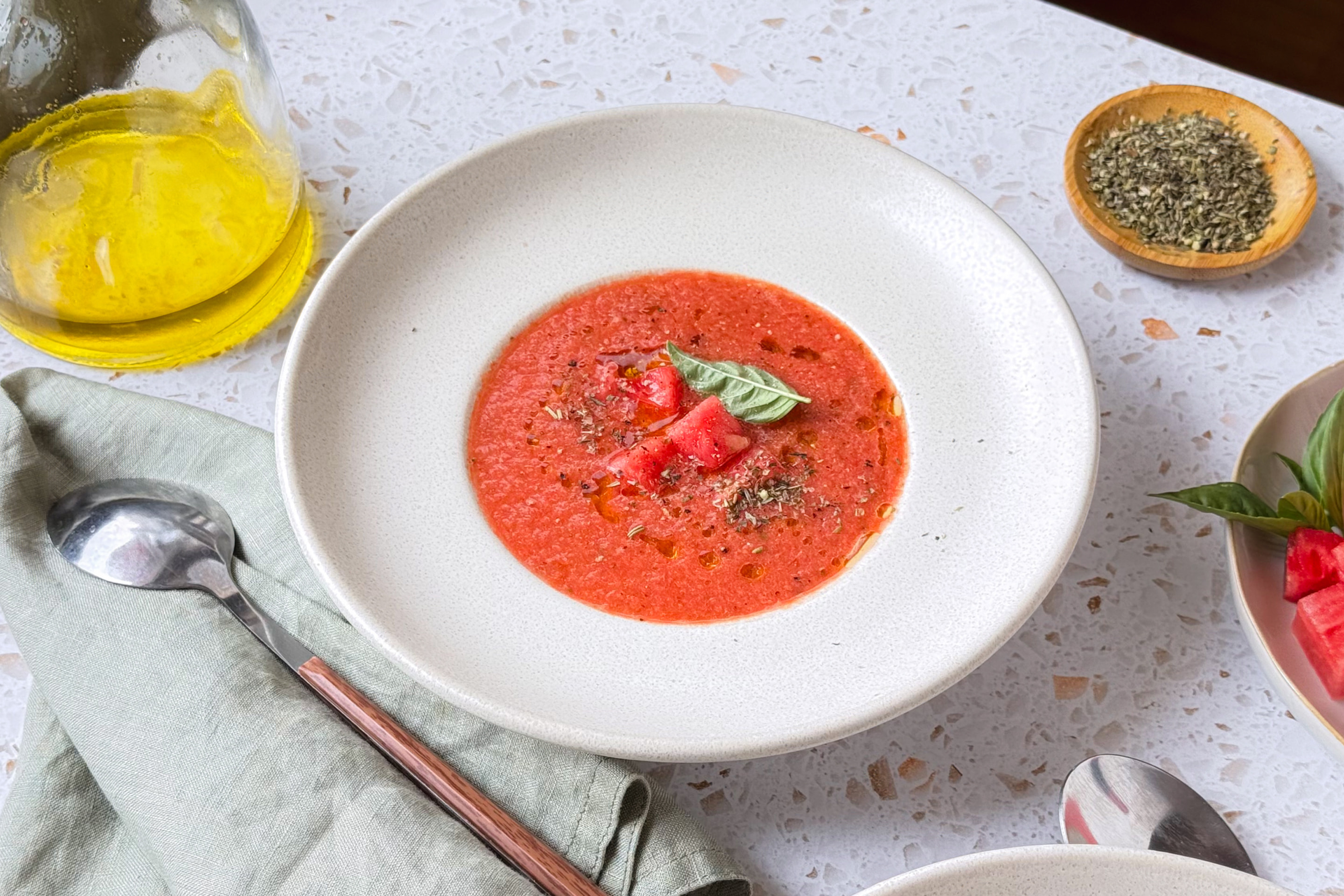 Kühles Wassermelonen Gazpacho, serviert mit Olivenöl